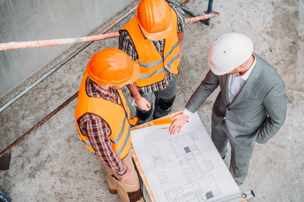 Generálkivitelező mérnökök építési ütemtervet egyeztetnek egy típusház projekt során