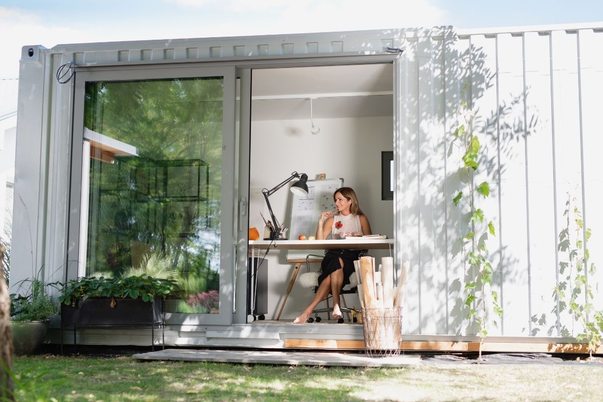 Konténerházból kialakított modern home office nagy üvegfelületekkel.
