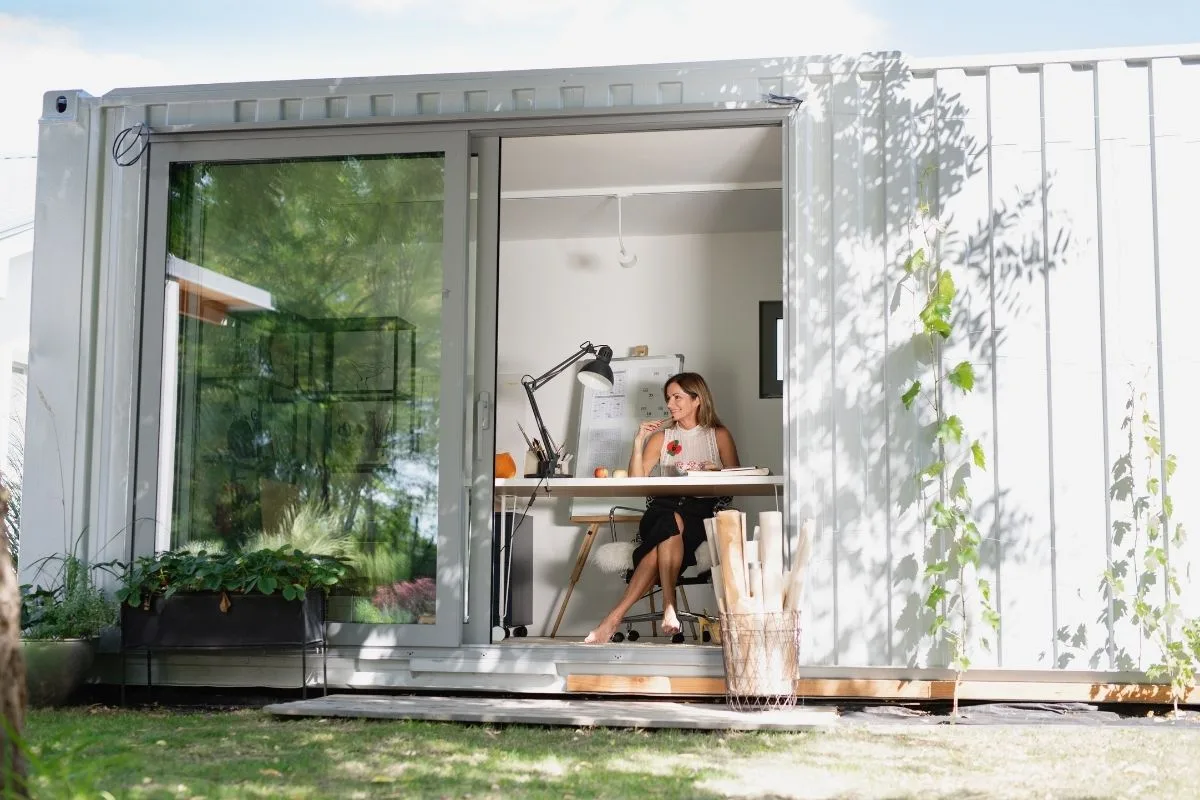 Konténerházból kialakított modern home office nagy üvegfelületekkel.